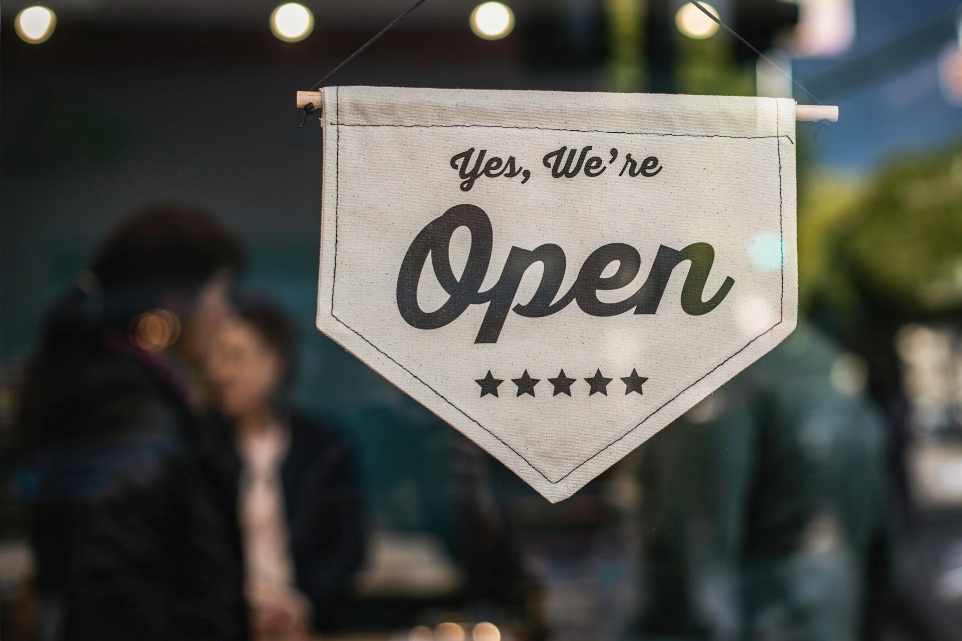 A hanging shop sign that reads Yes, we're open