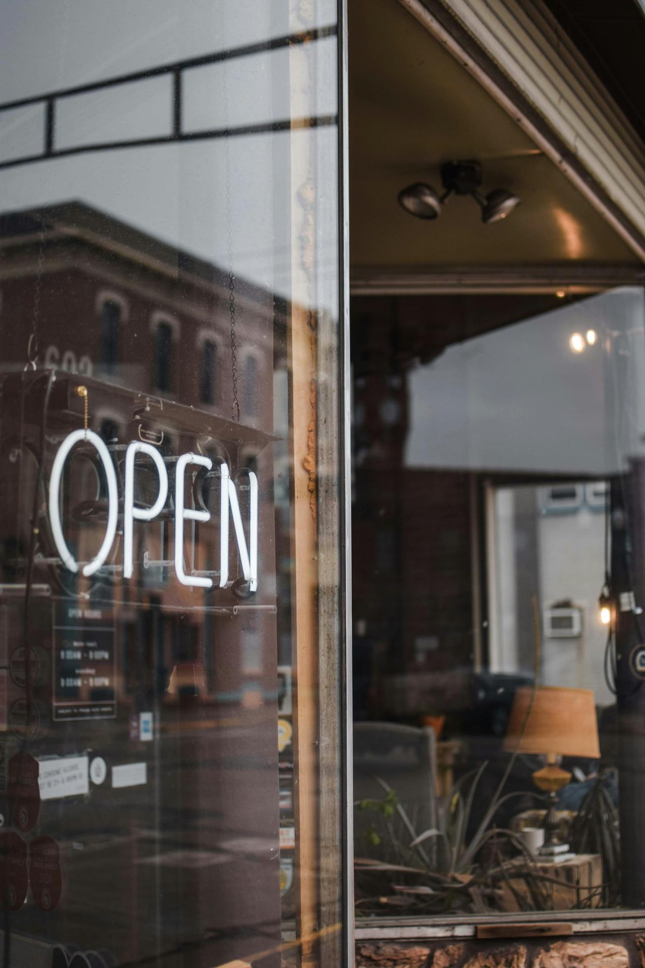 A lit OPEN sign in a storefront window